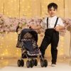 image of a boy with a checked dolls pushchair