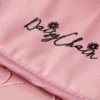 Daisy Chain Connect Dolls Pram in Classic Pink fabric. Close up of the apron with an embroidered Daisy Chain logo in black.