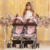 image of a girl a pink twin pushchair. The girl is dressed like shes a bridesmaid and there are flowers in the background