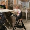 image shows a young girl with her daisy chain dolls high chair