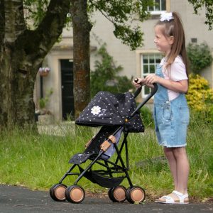 image of young girl with flower in her hair pushing the daisy chain zipp max dolls pushchair in limited edition twighlight pattern