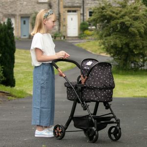 image of girl in blue jeans with the daisy chain connect 5 in 1 dolls pram in limited edition twighlight pattern