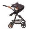 an image of a dolls pram from the side the pram has black fabric with a small white daisy pattern