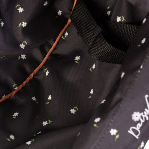 close up of a dolls high chair showing the black fabric with white daisy print