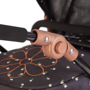 a close up image of a dolls pram that shows the black and rose gold frame