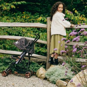 image shows a young girl in white coat with her limited edition twighligh dolls pushchair