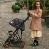 image shows a young girl in brown coat with her limited edition zipp zenith dolls pushchair