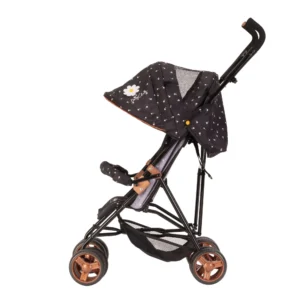 Daisy Chain Zipp Zenith Dolls Pushchair in Limited Edition Twilight fabric shown head on with the handles at the back. Hood is black with little daisies on the fabric with a white daisy rossette with a yellow centre on the side of the hood. Seat is black with daisies on it. It has a rose gold trim with an embroidered white Daisy Chain logo. The pushchair features a black bumper bar that can be raised up and down to make it easy to get your doll in and out of the pushchair. Wheels are rose gold with black tyres. With shopping basket at bottom of pushchair which is black. The frame of the pushchair is black with accents of rose gold.