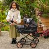 image of a young girl standing next to the daisy chain destiny travel system dolls pram