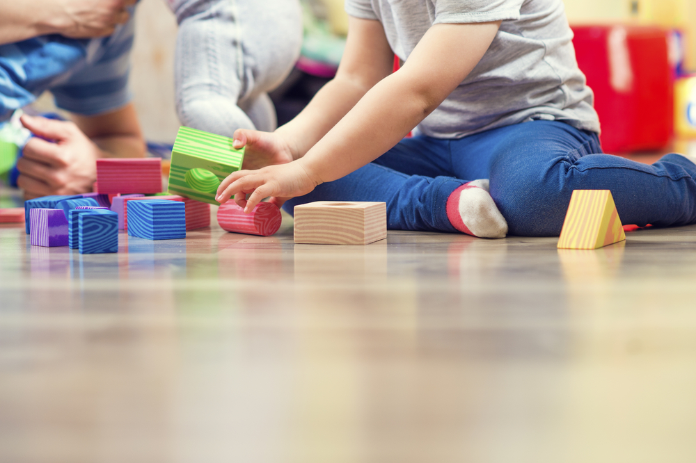 image of a child playing with colourful wooden building blocks