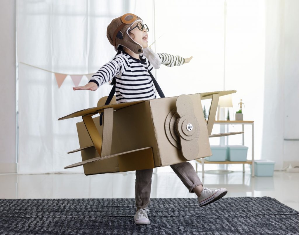 image of a young boy weaing an airplane costume made from cardboard boxes