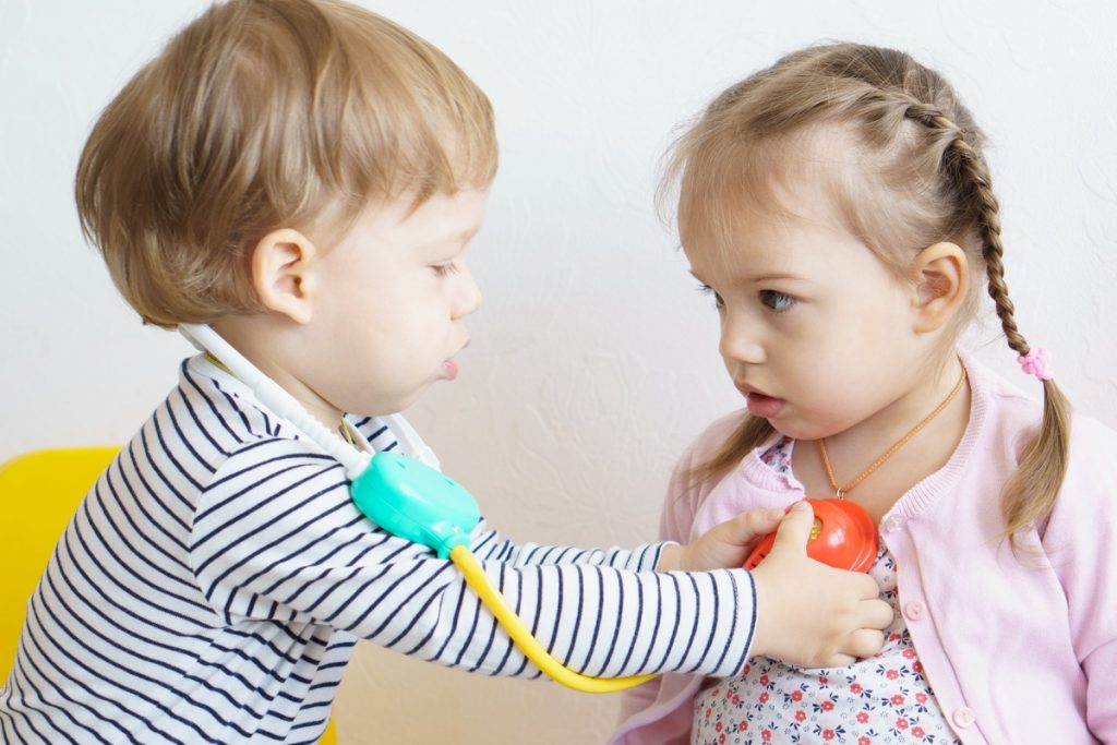 image of two children playing with a toy stethoscope