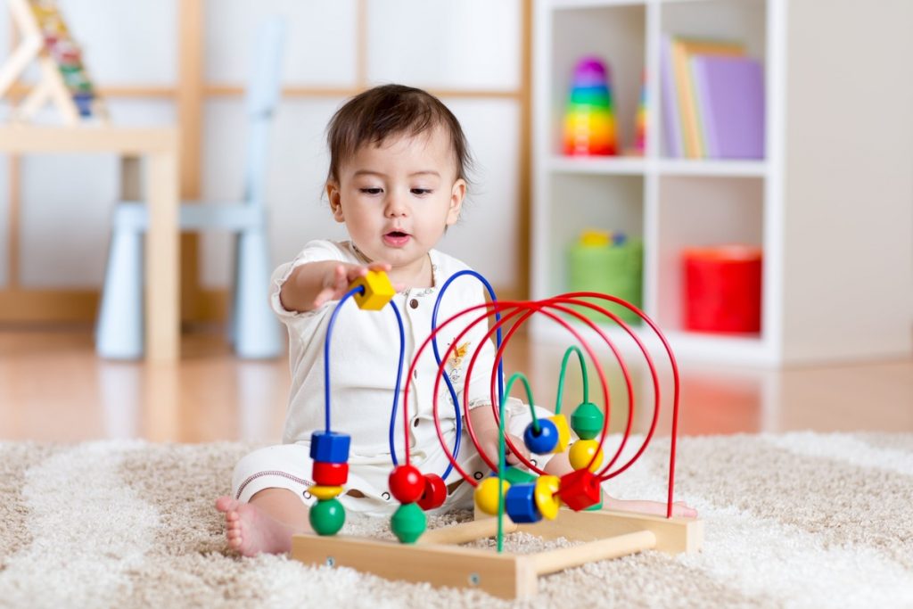 image of a baby playing with a brightly coloured toy