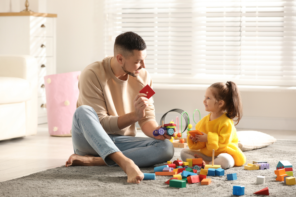 image of a man playing with building blocks with his daughter