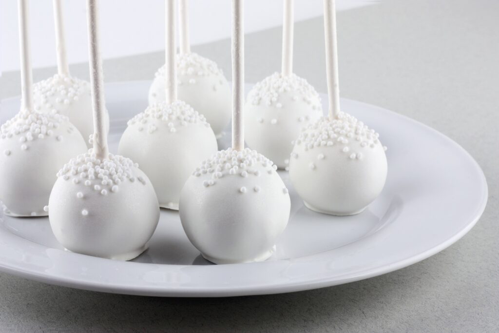 image shows eight snowy white christmas cake pops 
