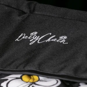 Detail of the Connect Dolls Pram apron showing the Daisy Chain logo embroidery