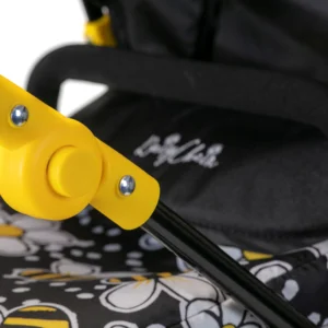 Detail of Daisy Chain Connect Dolls Pram apron and handle. Handle in foreground with yellow height adjuster and apron in background with out of focus Daisy Chain logo embroidery