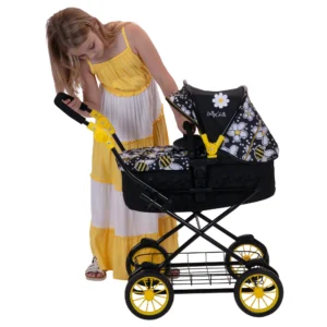 Daisy Chain Destiny Travel System Dolls Pram in Bumblebee fabric. The pram has a black frame, cot has a black quilted fabric body with an apron on top in bumblebee fabric and hood is half black and half bumblebee fabric. The pram has yellow wheels with black tyres. Girl in a yellow and white striped summer dress is looking inside the pram.