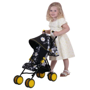Daisy Chain Little Zipp Dolls Pushchair has black and bumblebee fabric print and yellow wheels. Girl standing behind the pushchair in white knee length dress and white sandals. She has blond curly hair.