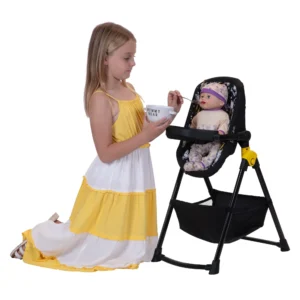 Daisy Chain Unity High Chair/Car Seat in Bumblebee fabric. High Chair seat is in bumblebee fabric with a black feeding tray. It sits on a black A-frame with a handy basket underneath for storage.. Girl with yellow and white striped summer dress is knelt feeding her doll which is sat in the high chair.