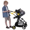 Boy pushing the Connect 5 in 1 Dolls Pram in pushchair mode. The pram has a bumblebee fabric, black frame and yellow accents