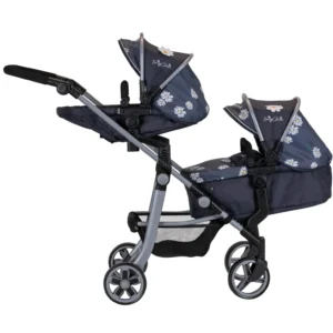 Daisy Chain Pinnacle Double Dolls Pram in Daisy Dot fabric for ages 6-13 years old. Hood is up and is mainly navy blue with accents of daisy's and white polka dots Silver metal with a white and yellow flower rosette and an with an embroidered Daisy Chain logo in white. There is a pushchair seat on the top part of the pram and a cot on the bottom. Wheels are black and Silver with a shopping basket at bottom of pushchair which is black. The frame of the pushchair is silver.
